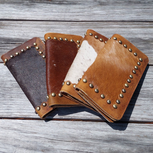 Credit card holder with snap closure | dark brown hide | auburn hide | tan and white hide | scalloped leather trim adorned with brass metal studs | Western long leather wallets | snap closure | opens flat like a checkbook | leatherncharm